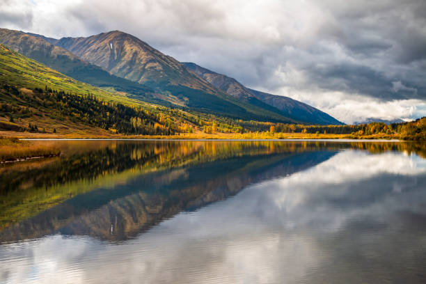istock dramatic sky and autumn foliage and mounter reflection on a tranquil lake in Kenai peninsula , Alaska 1393862808