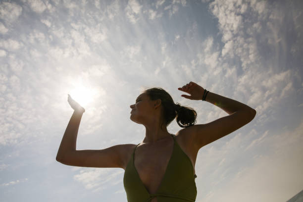 Low angle view of young woman in silhouette on the beach