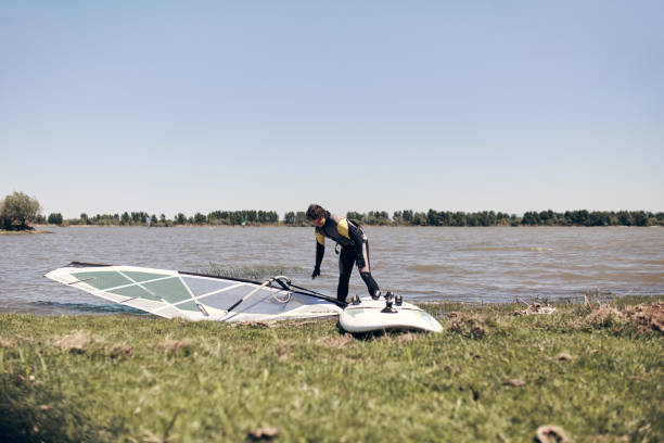 windsurfer w wietrzny letni dzień nad jeziorem. - windsurfing obrazy zdjęcia i obrazy z banku zdjęć