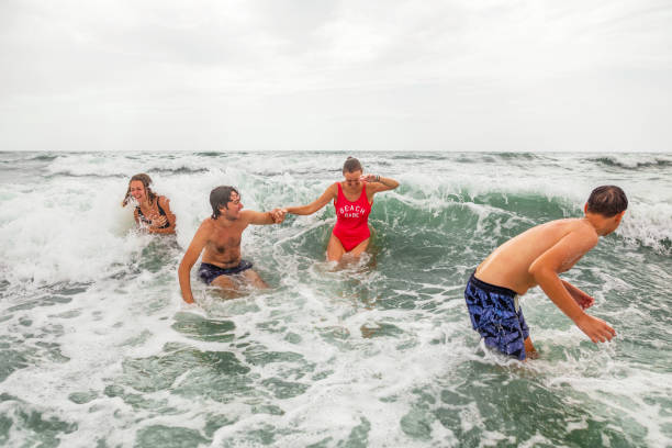 istock Caucasian male and female siblings having fun on vacation while waves splashing them 1393863989