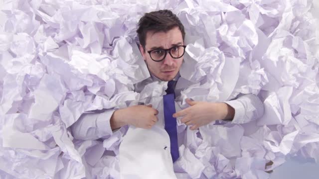 awesome man office worker in glasses in a large heaps of crumpled paper the view from the top