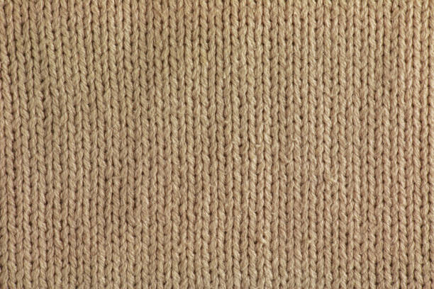 istock Beige knitted carpet close-up. Textile texture on a beige background. Detailed background from warm yarn. Natural wool fabric, sweater fragment. 1393865250