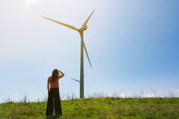istock Woman watching the wind power farm 1393867853