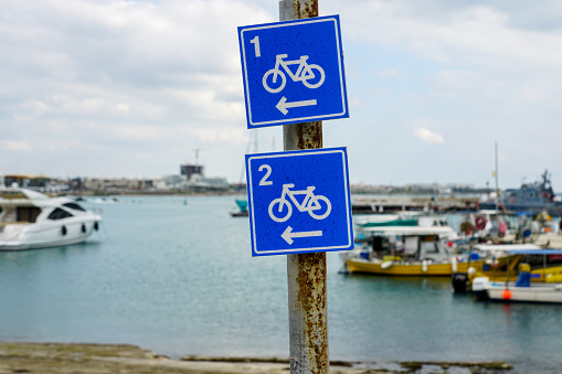 blue square shaped bicycle lane route signs with route numbers on a blurred background