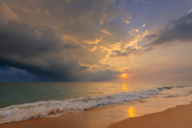 istock Gorgeous sunset sky with clouds over Indian ocean sandy beach with a foamy wave. Beautiful seascape. 1393871358