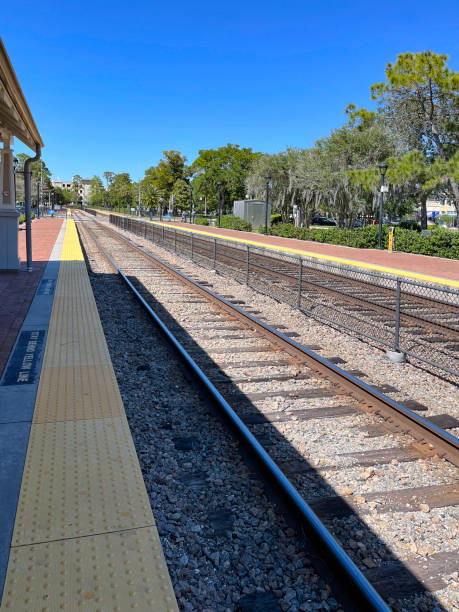 Bricked commuter rail station platform located on a double tracked line at Winter Park, Florida which serves interstate rail travelers, also. Bricked commuter rail station platform located on a double tracked line at Winter Park, Florida which serves interstate rail travelers, also. winter park florida stock pictures, royalty-free photos & images