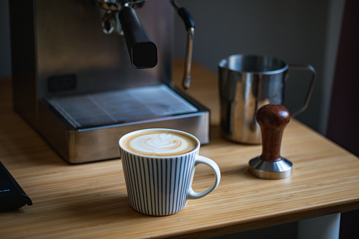 Latte art on wooden table with coffee equipments