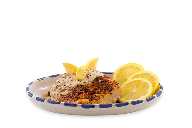 Baked Fish with Lemon Slices & Sauce stock photo
