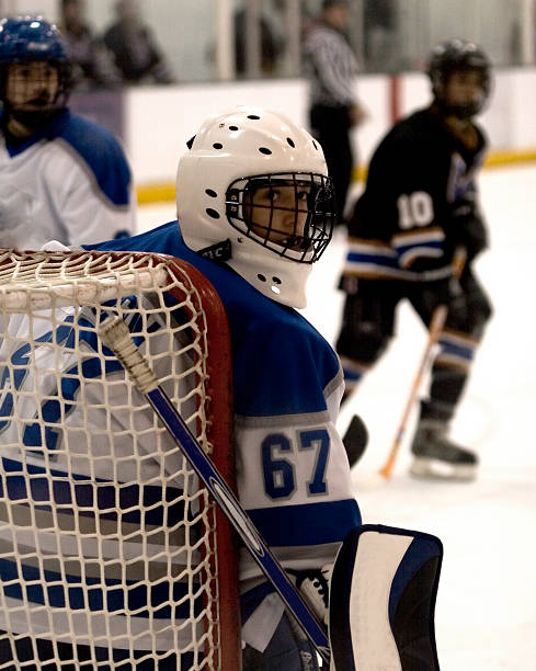 Goalie Looking Hockey goalie looks behind his net. checking ice hockey stock pictures, royalty-free photos & images