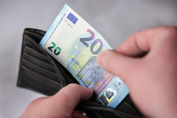 istock Takes out a 20 euro banknote from a leather wallet on a light background 1393880766