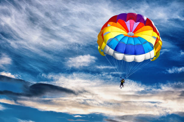 Gliding with a parachute. Gliding with a parachute on the background of bright sunset. parachuting stock pictures, royalty-free photos & images