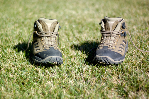 Hiking shoes on grass. Shallow depth of field w/focus on tip of the shoes.