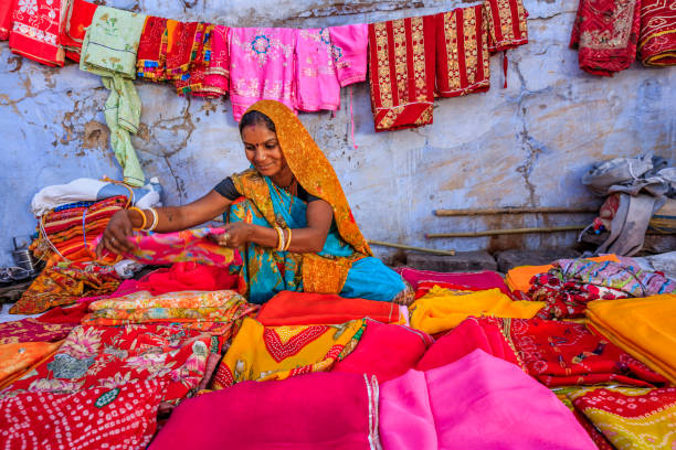 colors of india - woman selling colorful fabrics on local bazaar - sari imagens e fotografias de stock