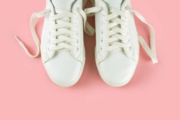 istock White sneakers on pink background 1393883965