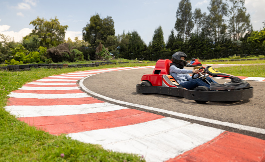 Competitive Latin American woman racing in go-carts and holding the wheel on a turn