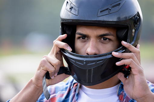 Portrait of a man putting on his helmet and getting ready to race in the go-carts