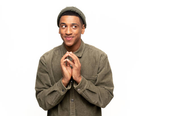 Sneaky man gesticulating with fingers planning devious tricks and cheats, scheming prank, having fun. Indoor studio shot isolated on white