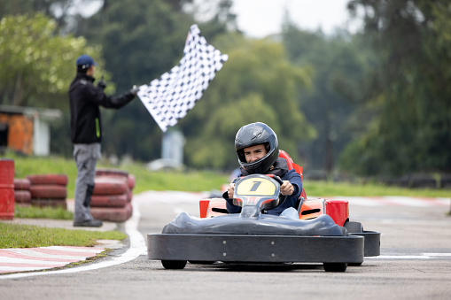 Competitive Latin American man racing in go-carts and crossing the finishing line