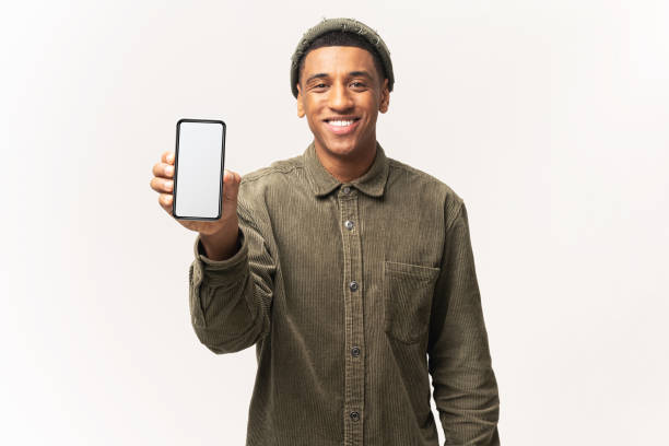 istock Positive confident man showing smartphone with white empty display, bragging with application. Indoor studio shot isolated on white 1393884952