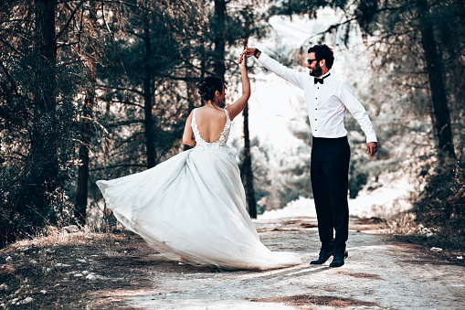 Wedding couple posing in forest.