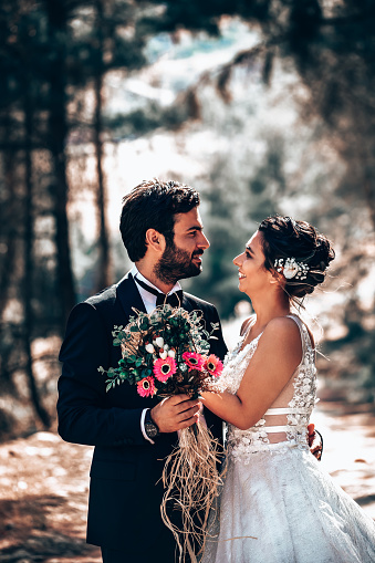 Wedding couple posing in forest.