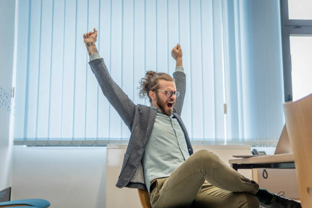 istock Young businessman yawning and stretching while working 1393887184