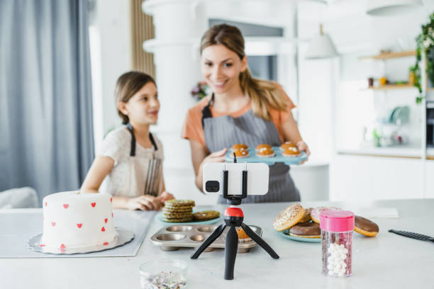 istock Female vlogger filming a tutorial together with her daughter about decorating a sweets 1393887849