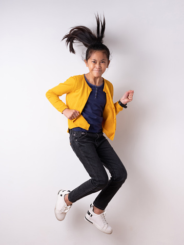 Energetic jumping kids in studio with white background