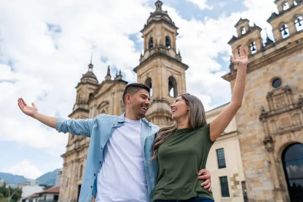 Latin American couple looking very happy sightseeing in Bogota at the Plaza de Bolivar - travel concepts