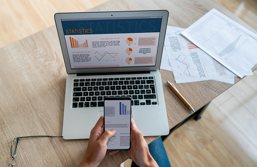 Close-up on a businessman using financial technology on different devices while working at home