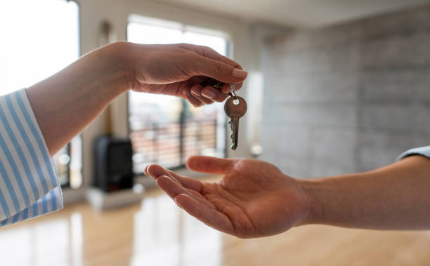 agente inmobiliario entregando las llaves de su nueva casa a un hombre - vender fotografías e imágenes de stock