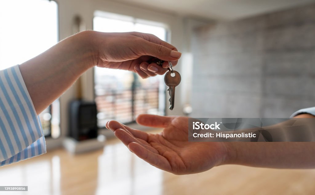 Real estate agent giving the keys of his new house to a man Close-up on a real estate agent giving the keys of his new house to a man - home ownership concepts Apartment Stock Photo