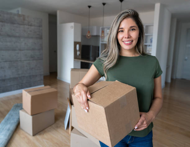 istock Happy woman moving house and packing in boxes 1393890907