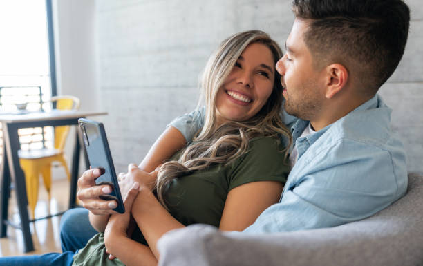 istock Couple lauging while watching videos on their cell phone 1393890908