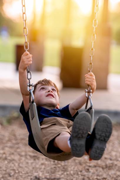istock Little boy swinging in the playground 1393891775