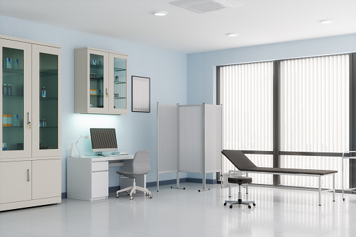 Doctor's office with desk, cabinets and examination table.
