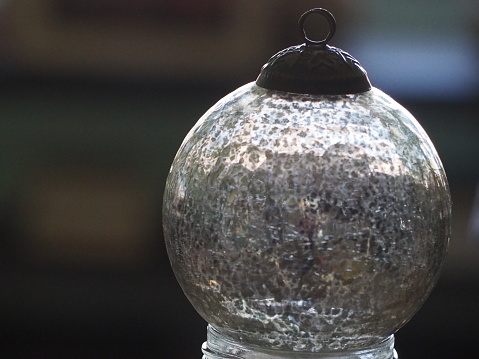 A horizontal close-up of a fancy glass bottle top.