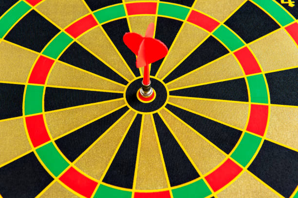 istock Dart game, dartboard with red dart in the center. 1393893571