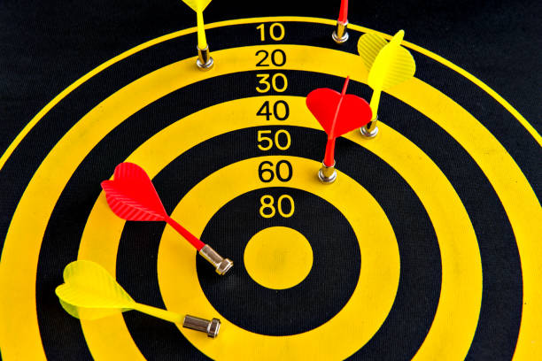 istock Darts game, yellow and black dartboard with sticky darts 1393893574