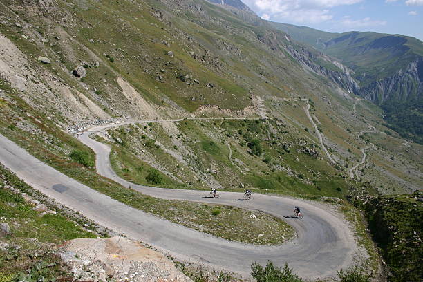 Three cyclists descending a mountain stock photo