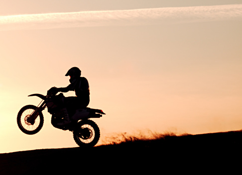 Silouhetted motociclista en puesta de sol photo