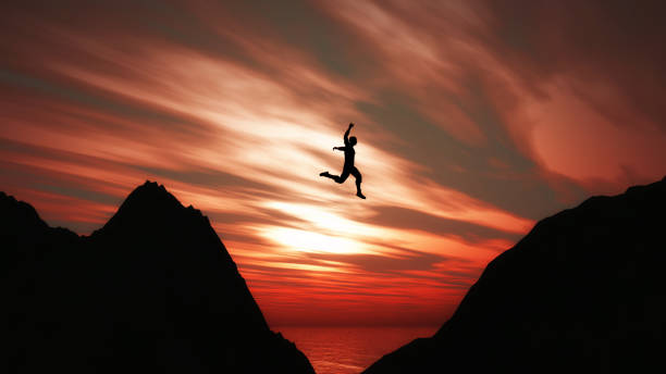 istock 3D landscape with silhouette of male jumping between cliffs 1393897361
