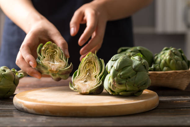 carciofo verde su tavola di legno prepararsi per cucinare - carciofo foto e immagini stock