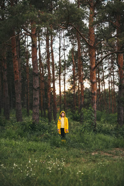 istock Kid in raincoat in green forest 1393901666