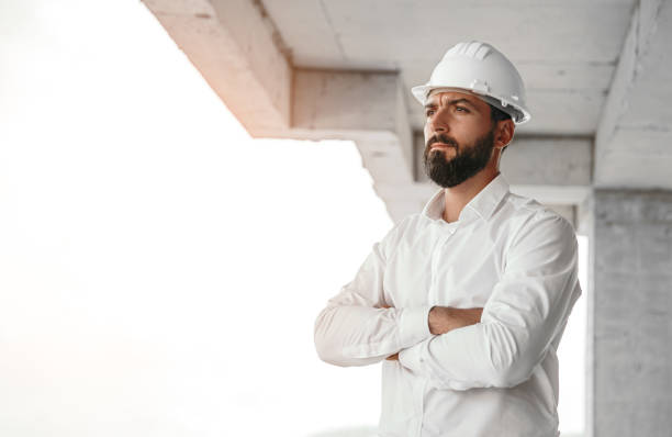 istock Serious ethnic male contractor looking away at construction site 1393901714