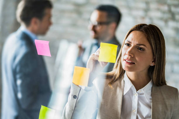 istock Female entrepreneur writing business plans on adhesive notes. 1393902932