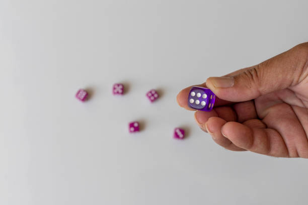 Holding blue dice in hand with a face with six dots
