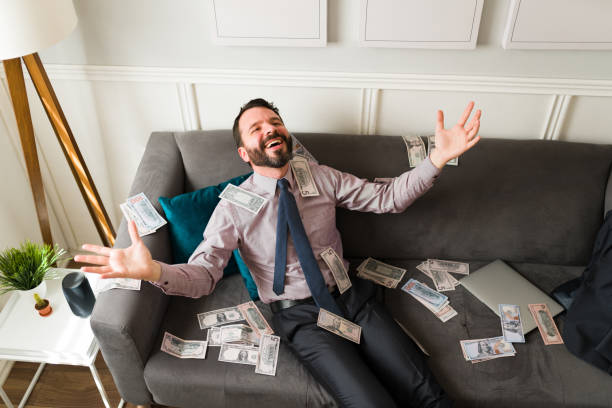 istock Smiling man throwing money in the air 1393904403