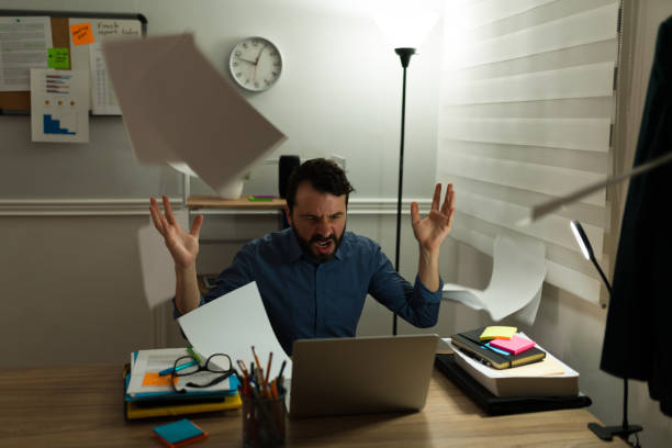 istock Annoyed man overworking at the office 1393905109
