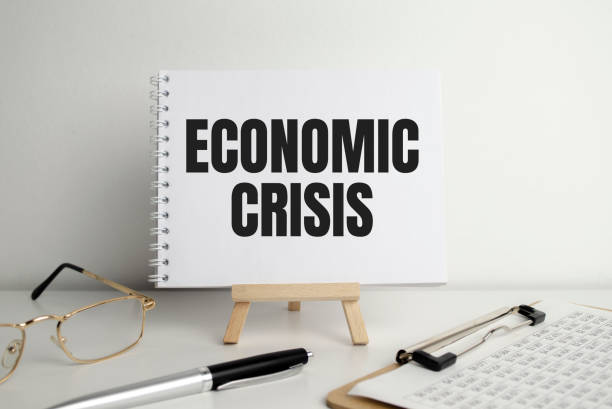 istock Economic crisis words on the notepad on the easel and glasses. 1393909247